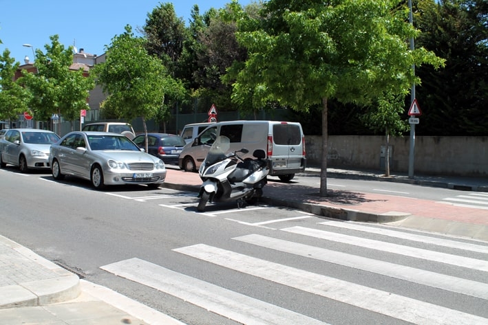Un dels passos de vianants del carrer Céllecs amb els aparcaments de motos al costat 