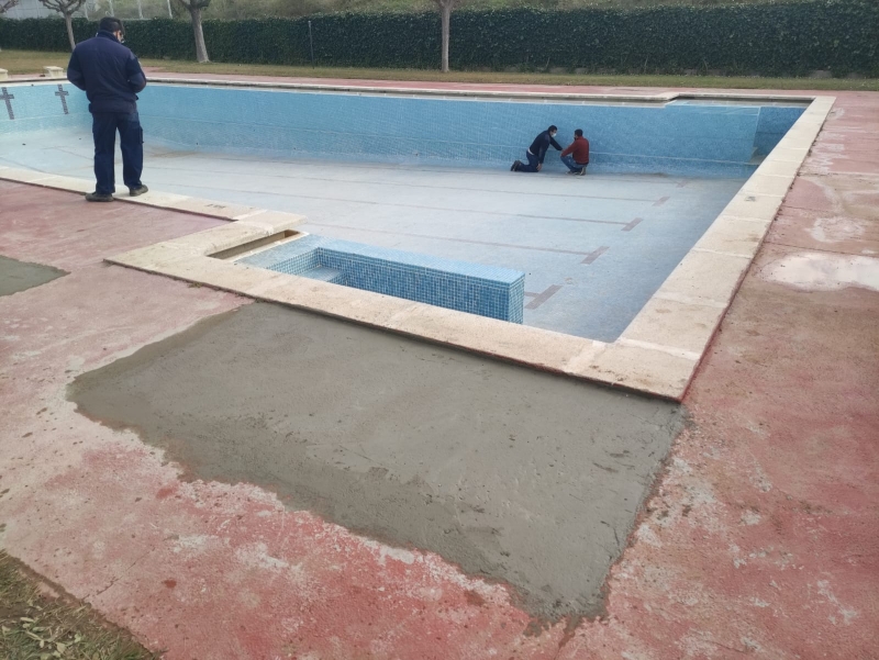Tècnics realitzant el manteniment i les millores a la piscina descoberta